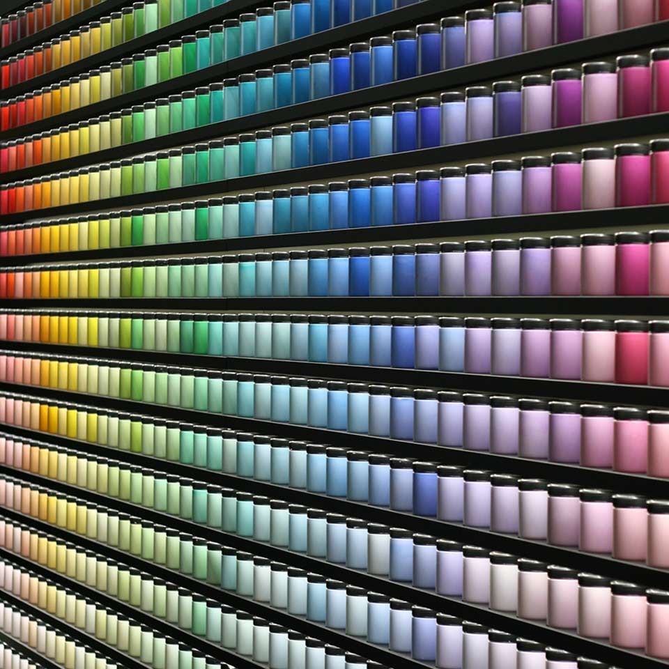 Image of wall filled with brightly coloured paint sample pots